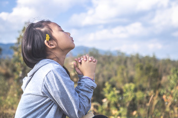Little girl praying to God. Peace, hope, christian concept.