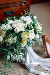 Wedding arch decor with flowers. Bride's bouquet with shoes in the hotel.