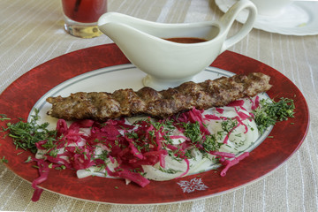 Kebab. Traditional Middle-Eastern Food. It is a long cutlet roasted on the grill and a gravy with spicy tomato sauce.