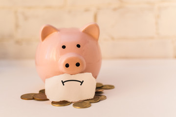 pink piggy Bank is sad. The concept of poverty