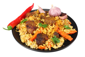 pilaf with meat and chili pepper on black plate isolated on white background.