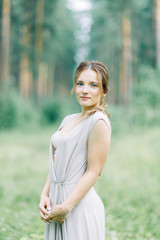 Boudoir photo shoot of the bride in the woods with a bouquet. Flying dress and beautiful girl in the Park.