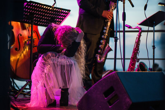 Young female singer is performing on stage. Concept of emotional music, lyrics. Romantic, calming and relaxing concert