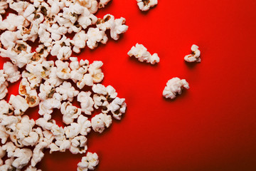 Tasty salted popcorn isolated on red background