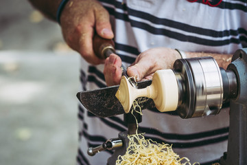 Artisan tourneur sur bois en train de fabriquer une toupie