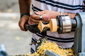 Artisan tourneur sur bois en train de fabriquer une toupie