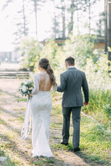 Fototapeta premium Wedding ceremony at the arch with pine forest in the style of fine art. Beautiful couple and traditions at a wedding in Europe.