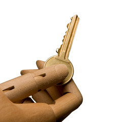 An artists mannequin hand presenting a house door key on a plain background