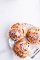 Cinnamon rolls buns on a white marble wooden background. Bakery concept. Breakfast and brunch. Flatlay. Minimalistic photo. Overhead. Copy space