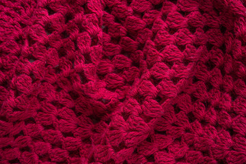 Soft folds of a warm red knitted woolen poncho to be used as background