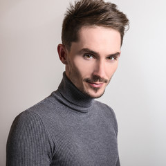 Obraz premium Handsome young elegant man in grey golf.