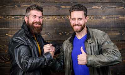 Have agreed. Brutal bearded men wear leather jackets shaking hands. Strong handshake. Friendship of...