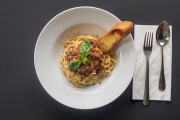 Pasta bolognese on a white plate on a dark background