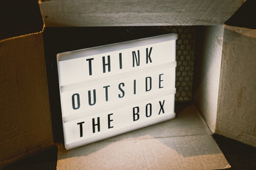 Think outside the box message on lightbox with parcel,