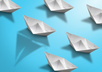 stand out concept, paper ship with sailing boat shadow