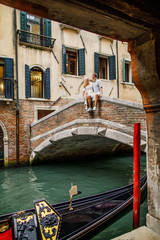 Young beautiful couple girl in dress man in white shirt walk through the streets of Venice Italy © Alexander