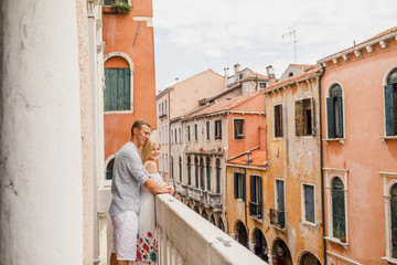Young beautiful couple is standing on the balcony overlooking beautiful Venice