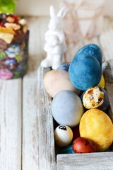 Colored Easter eggs in a wooden basket on a white background. Happy easter. Easter decoration.