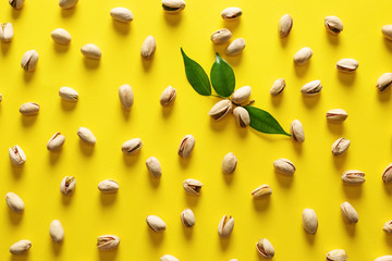 Tasty pistachio nuts on color background