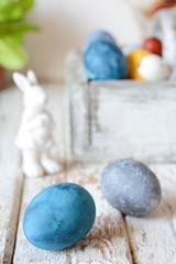 Colored Easter eggs in a wooden basket on a white background. Happy easter. Easter decoration.