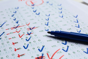 Felt-tip pen on checked answer sheet, closeup. Concept of passing exam
