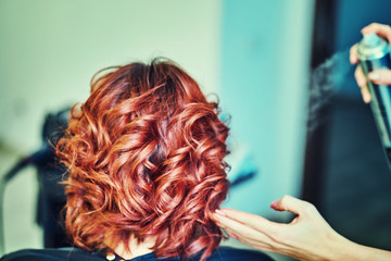 Fototapeta premium Image of a hairdresser applying extensions to a client's hair