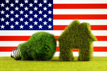 Green eco light bulb, eco house icon and United States Flag. Renewable energy. Electricity prices, energy saving in the household.