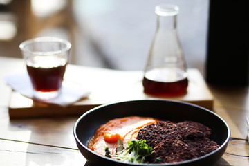 Vegan healthy black rice cutlets served with orange carrots mesh and microgreeens and decaf coffee. Vegeterian food.
