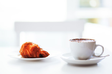Cappuccino coffee and croissant isolated on white background