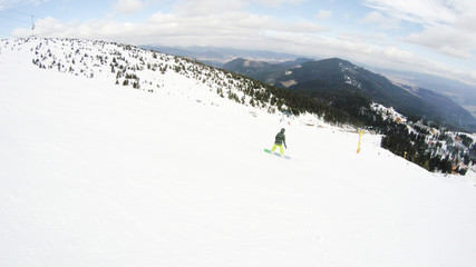 Fototapeta premium A girl rides a snowboard in the mountains. Lots of snow. Carpathians. Ski jacket and trousers.