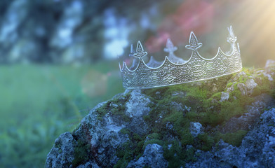 mysterious and magical photo of silver king crown over the stone covered with moss in the England...