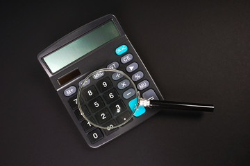 Calculator and magnifier glass with financial concept.