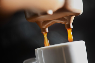 Macro photo of making fresh espresso coffee in a coffee machine. Breakfast