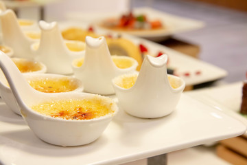  creme brulee in white spoon on plate