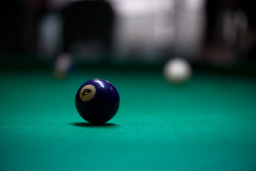 Sport billiard balls on green billiard table in pub. On going billiard game. Competitive players...