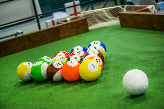 Shot of foot pool balls standing on green table. Foot Pool is the hybrid combination of pool and soccer. Big billiard balls. 
