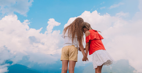 Beautiful happy little girls in mountains in the background of fog © travnikovstudio