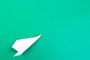 Travel and journey concept. White paper plane on green background.