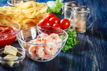 Ingredients ready for preparing pappardelle pasta with shrimp, tomatoes and herbs