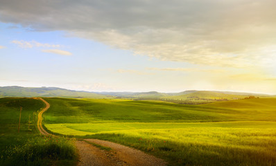 Fototapeta na wymiar spring farmland and country road; tuscany countryside rolling hills