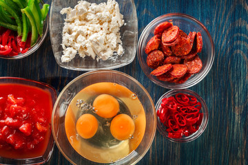 Ingredients for preparing frittata - eggs, sausage chorizo, red