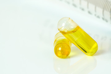 Olive capsules and syringe  with white background.