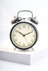 Clock and book with white background.