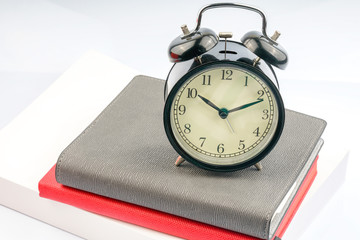 Clock and book with white background.