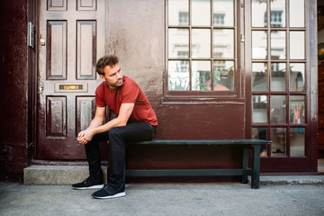 Man sitting in a bench on a beautiful maroon background