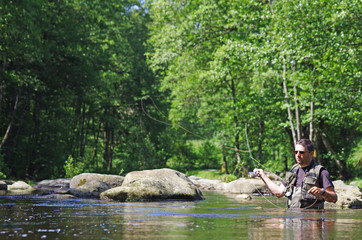 Obraz na płótnie Canvas Fly fishermen in action. Catch of fish, fly fishing scene, freshwater fishing, trout fishing