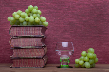 Renaissance, rummer wine glass, old books and grapes