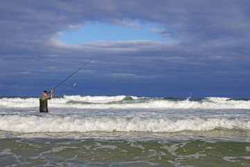 Surf fisherman into the waves. Sea fishing, catch of fish