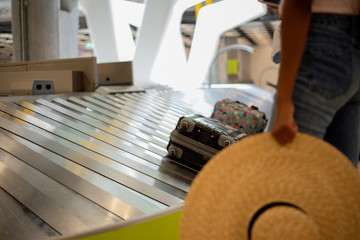 Woman waiting at a conveyor luggage airport