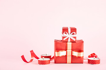 Happy Valentine's day concept. Close up composition with presents wrapped in colorful paper and tied with satin bow, traditional lovers day holiday attributes. Copy space, background, top view.